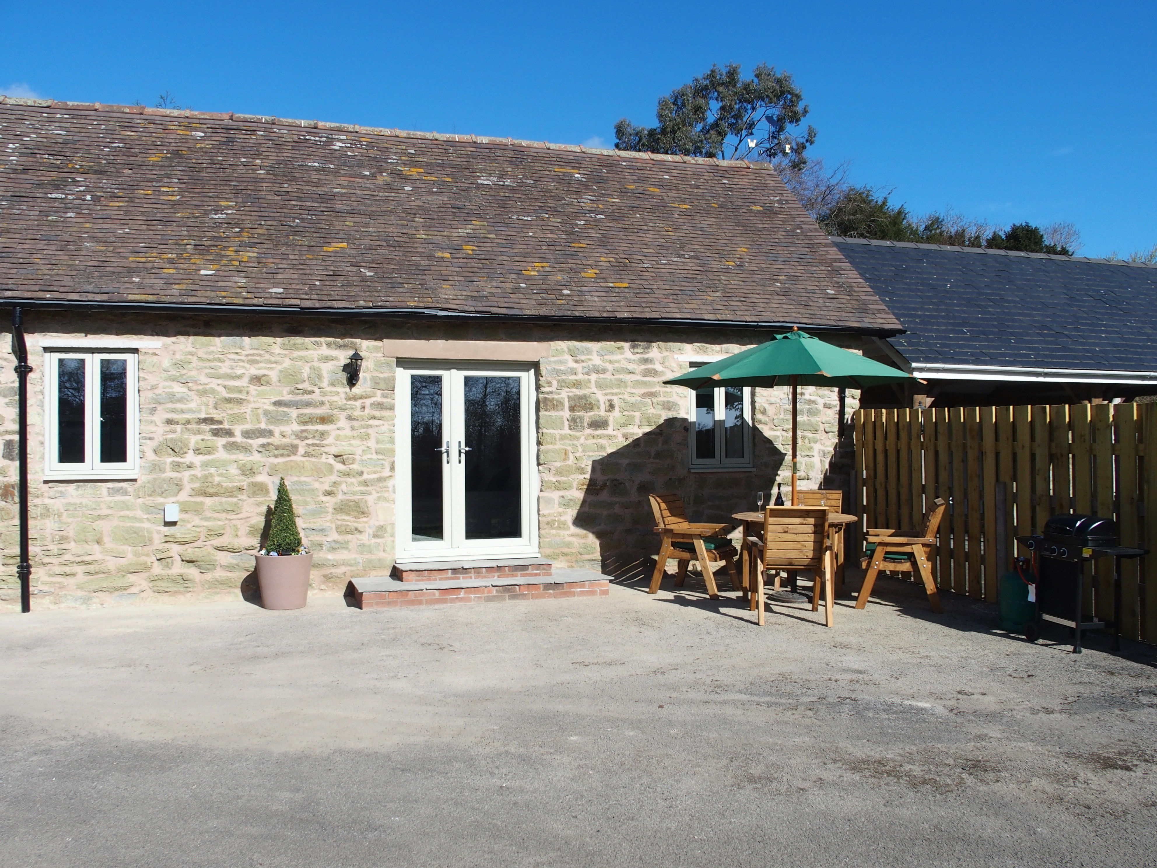 A gas BBQ & dining area outside Orchard Barn